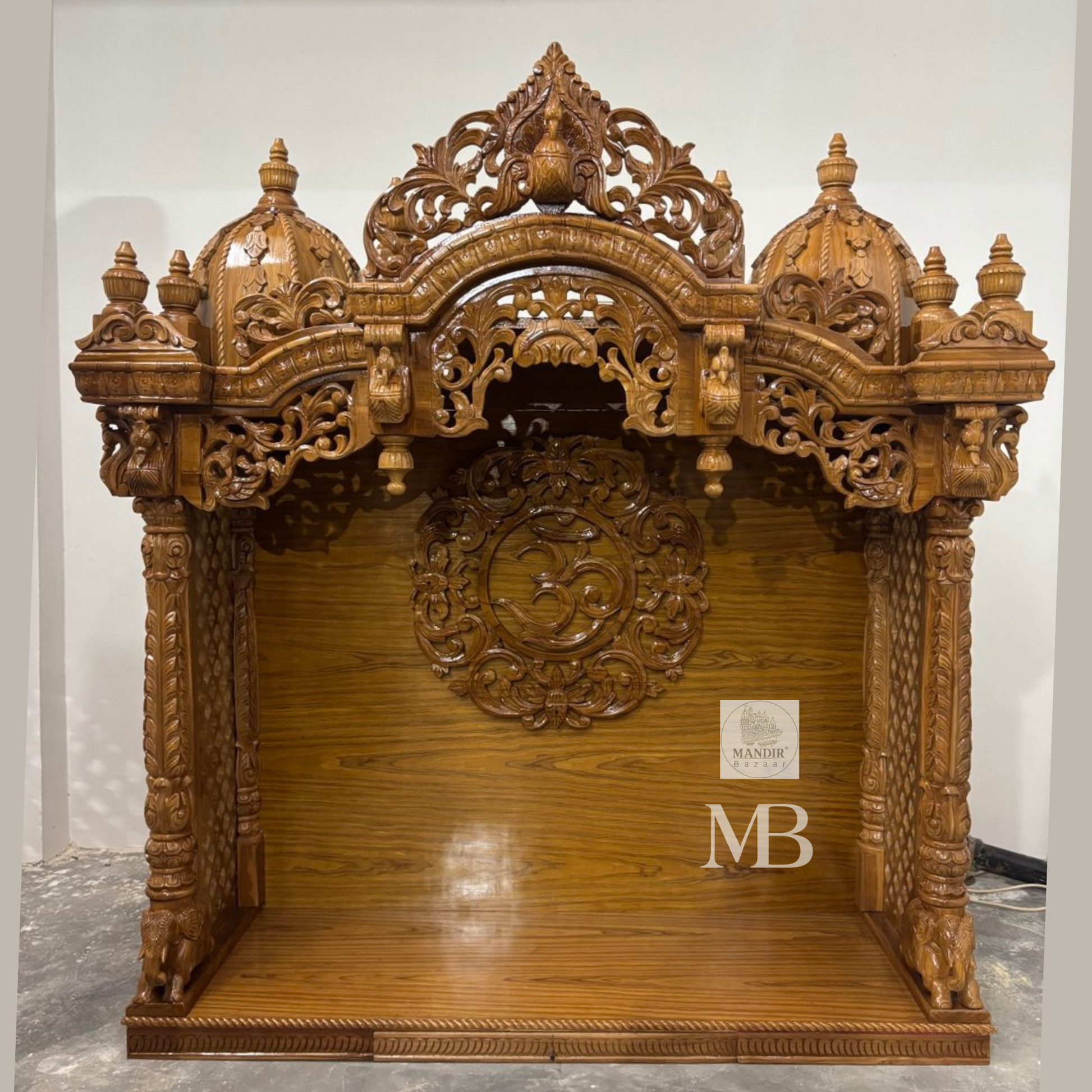 Wooden Hindu temple with carved OM symbol floral details and elephant motifs