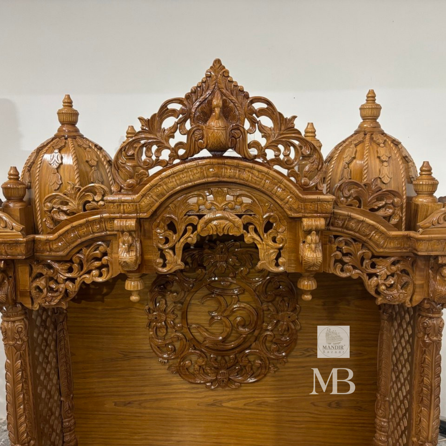 Wooden Hindu temple with carved OM symbol floral details and elephant motifs