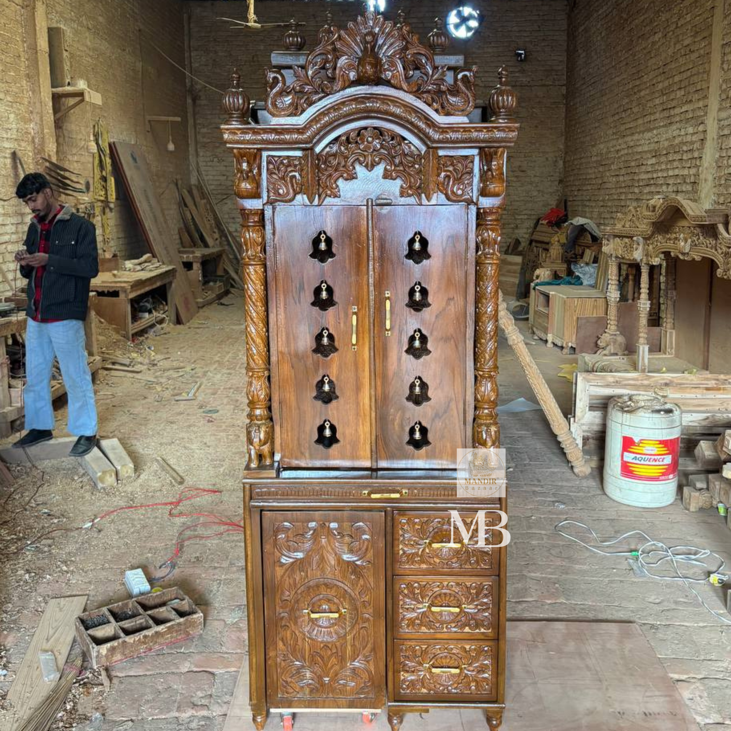 Luxury handcrafted solid teak wood pooja mandir with brass bells, carved pillars, storage cabinet, three drawers, walnut brown finish, traditional Hindu temple for home by Mandir Bazaar.