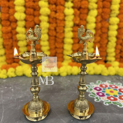 Traditional brass oil lamps with peacock design for pooja
