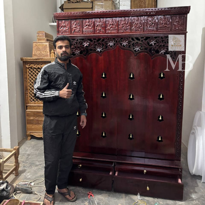 Dark brown wooden pooja mandir with carved floral panels, brass bell accents and spacious storage drawers