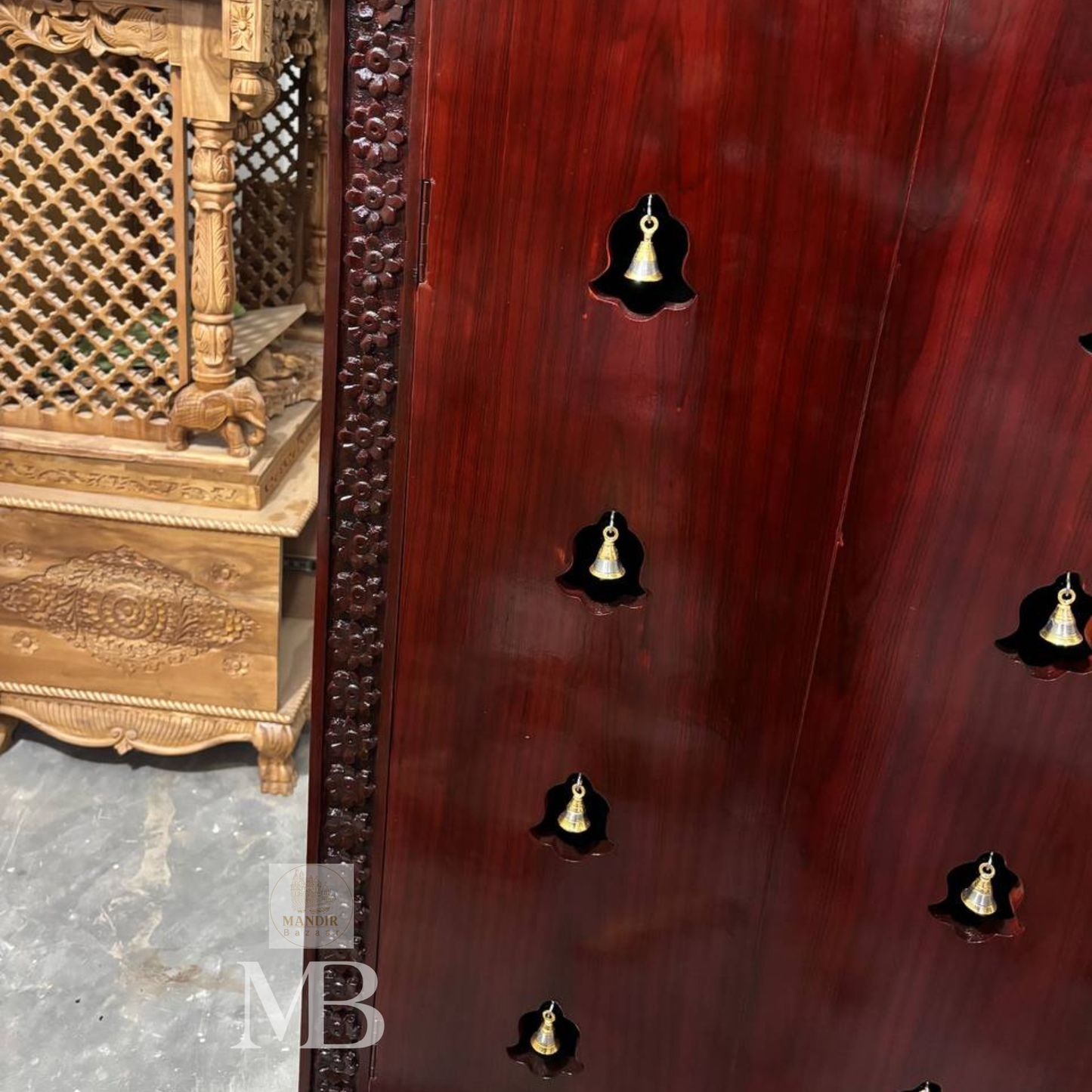 Dark brown wooden pooja mandir with carved floral panels, brass bell accents and spacious storage drawers