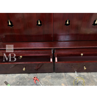 Dark brown wooden pooja mandir with carved floral panels, brass bell accents and spacious storage drawers