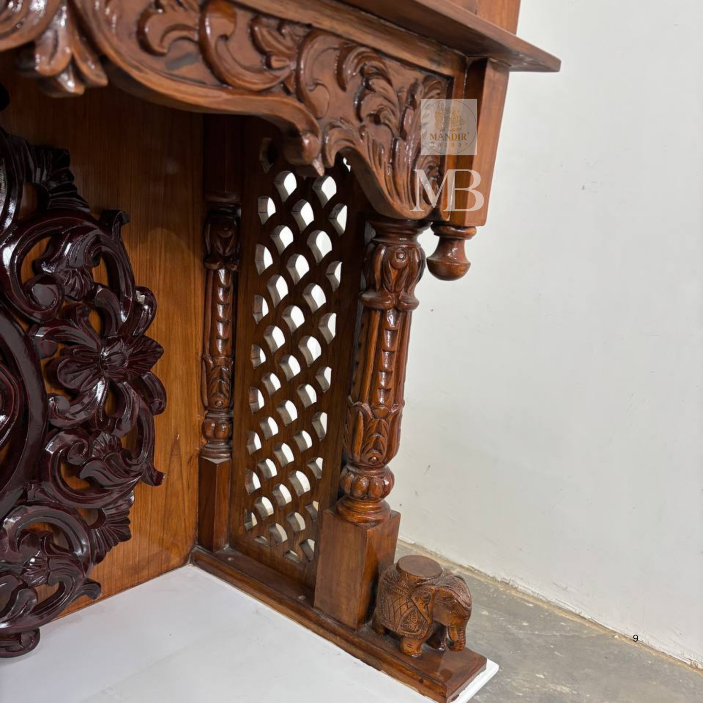 Traditional wooden home temple with carved pillars and decorative deity panels