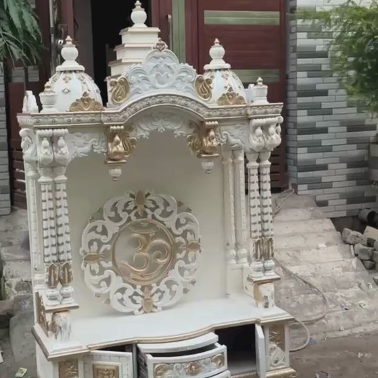 White and gold hand carved wooden mandir for home with Om design and storage cabinet