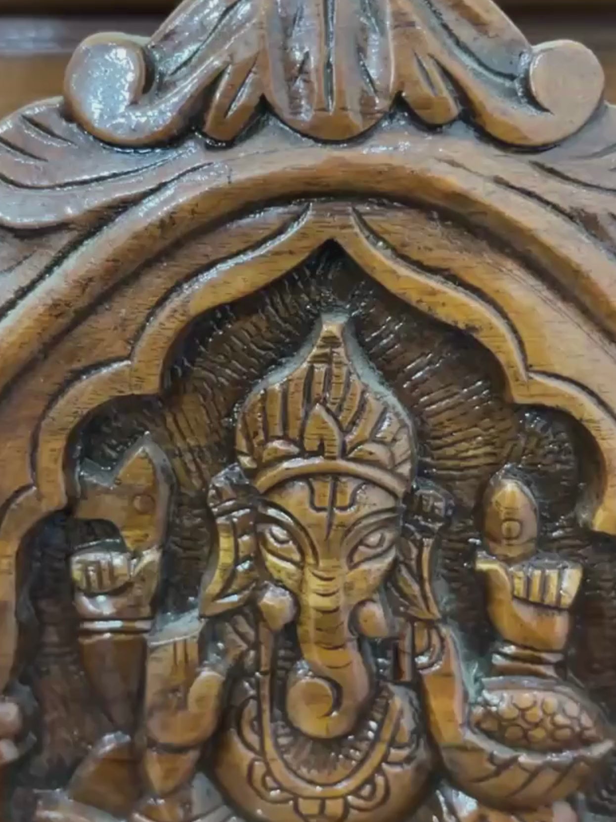 Traditional wooden home temple with carved pillars and decorative deity panels