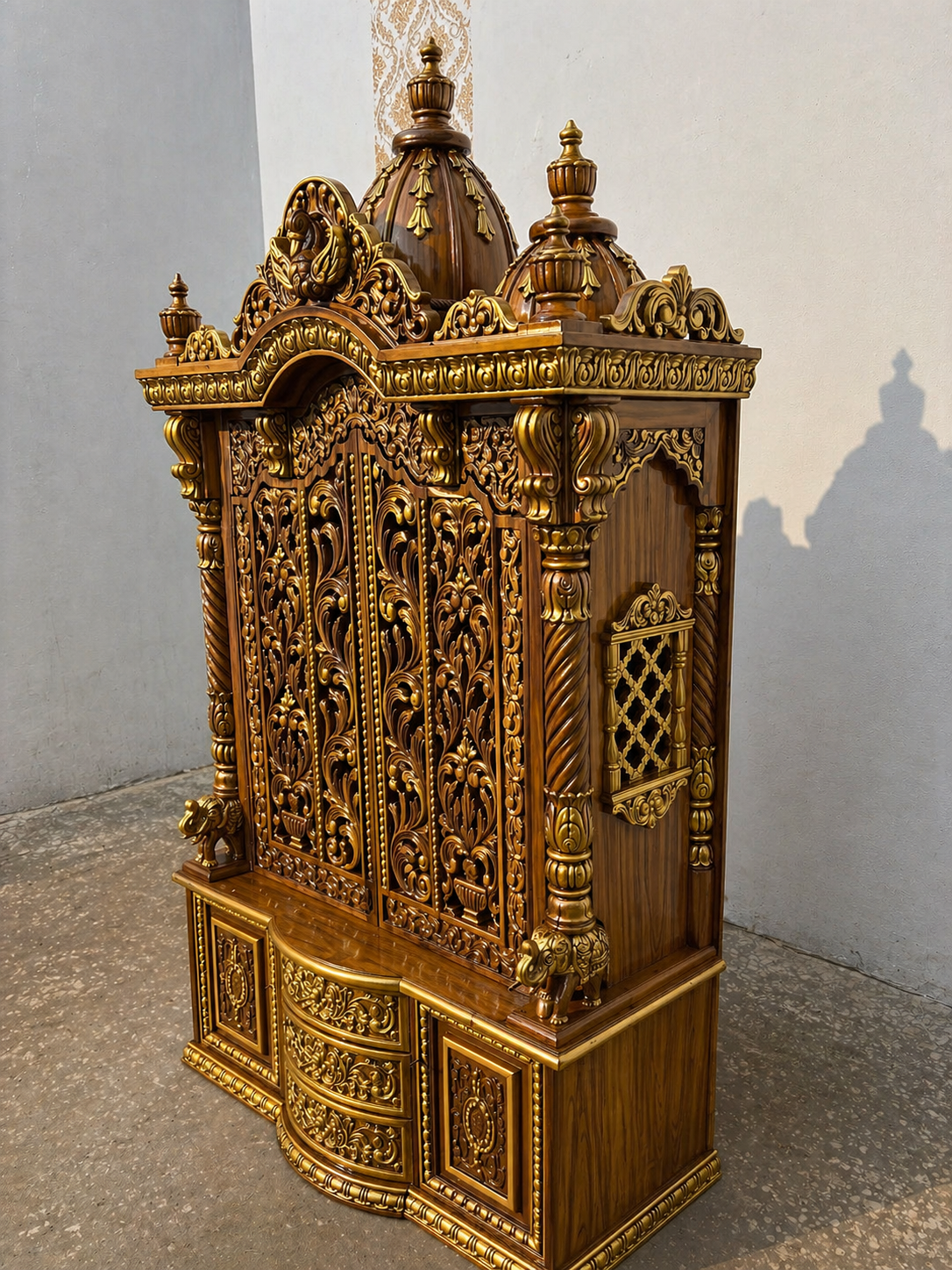 Side angle view showing side jali window, twisted pillars, and elephant base on Sheesham wooden temple