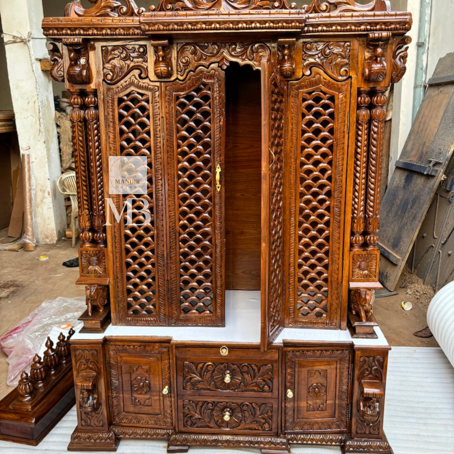 Bottom storage cabinet featuring floral carved drawers and side doors on antique Sheesham wooden temple
