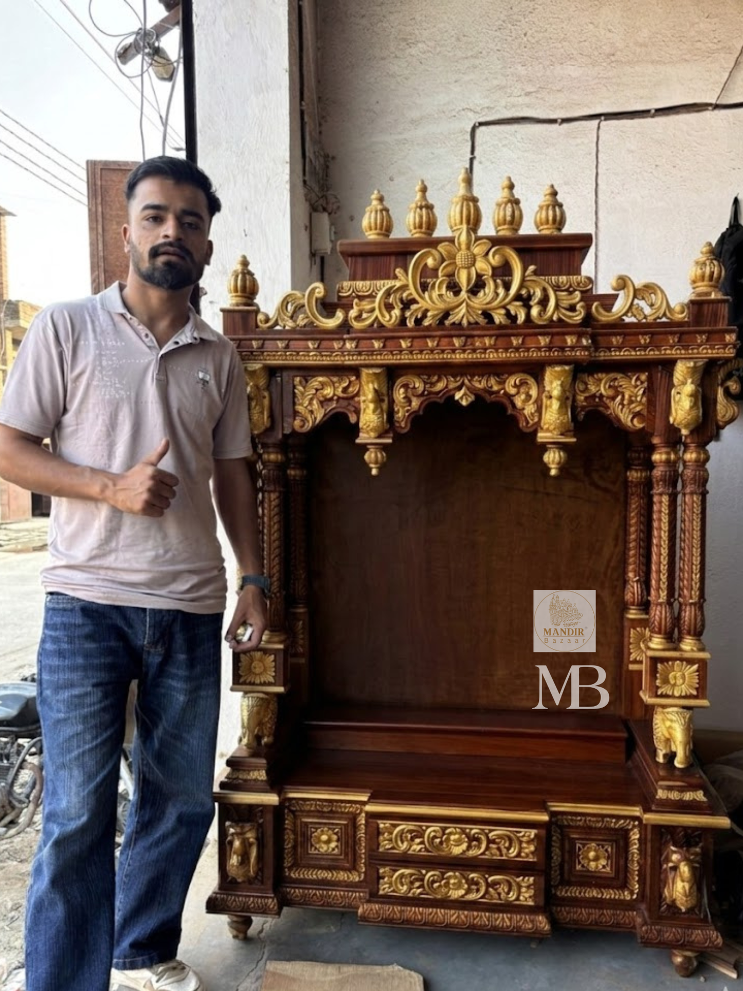 Detailed close up of golden kalash finials and hand-carved floral arch crown on dark wood temple