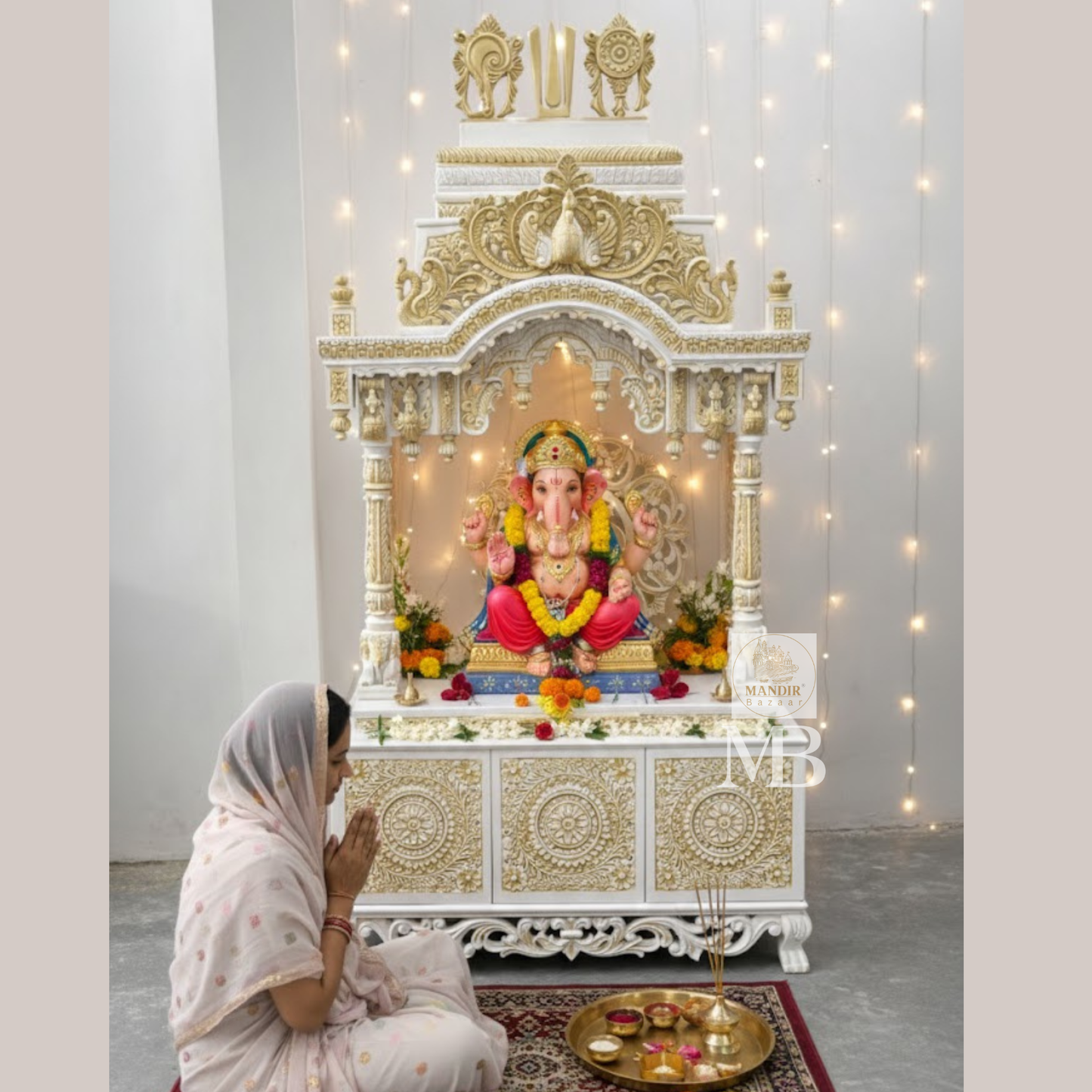 Luxury Sheesham wood home temple showing white and gold hand carved jaali panels, pillars and elephant details