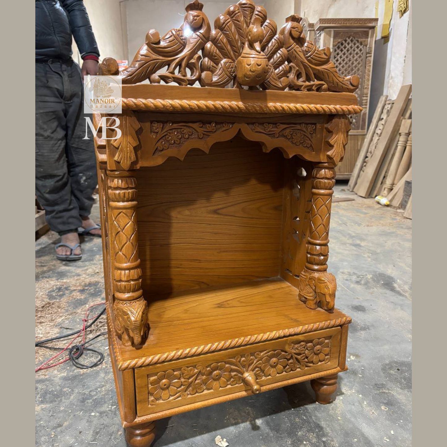 Side perspective view of Sheesham wood tabletop temple highlighting carved peacock side jali panel and elephant pillar