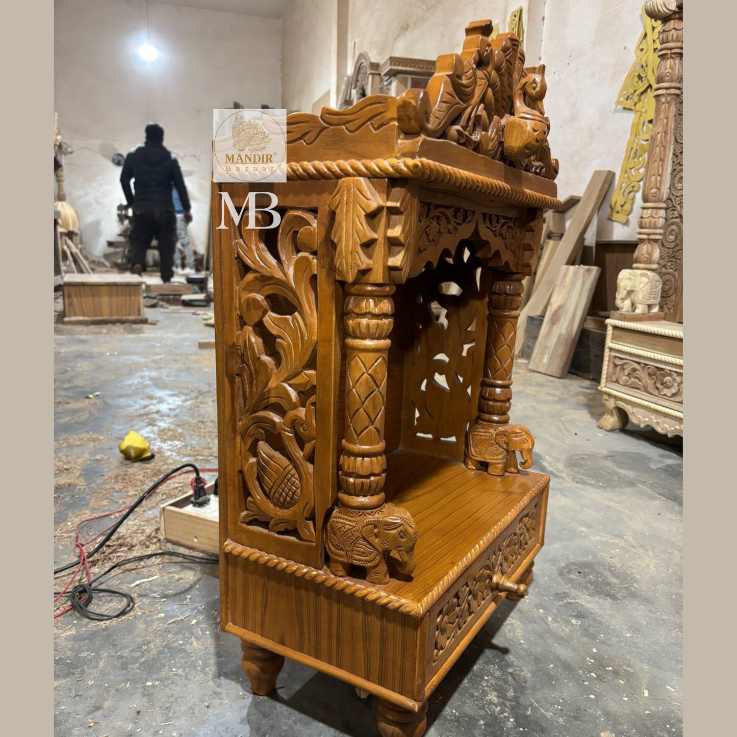 Side perspective view of Sheesham wood tabletop temple highlighting carved peacock side jali panel and elephant pillar