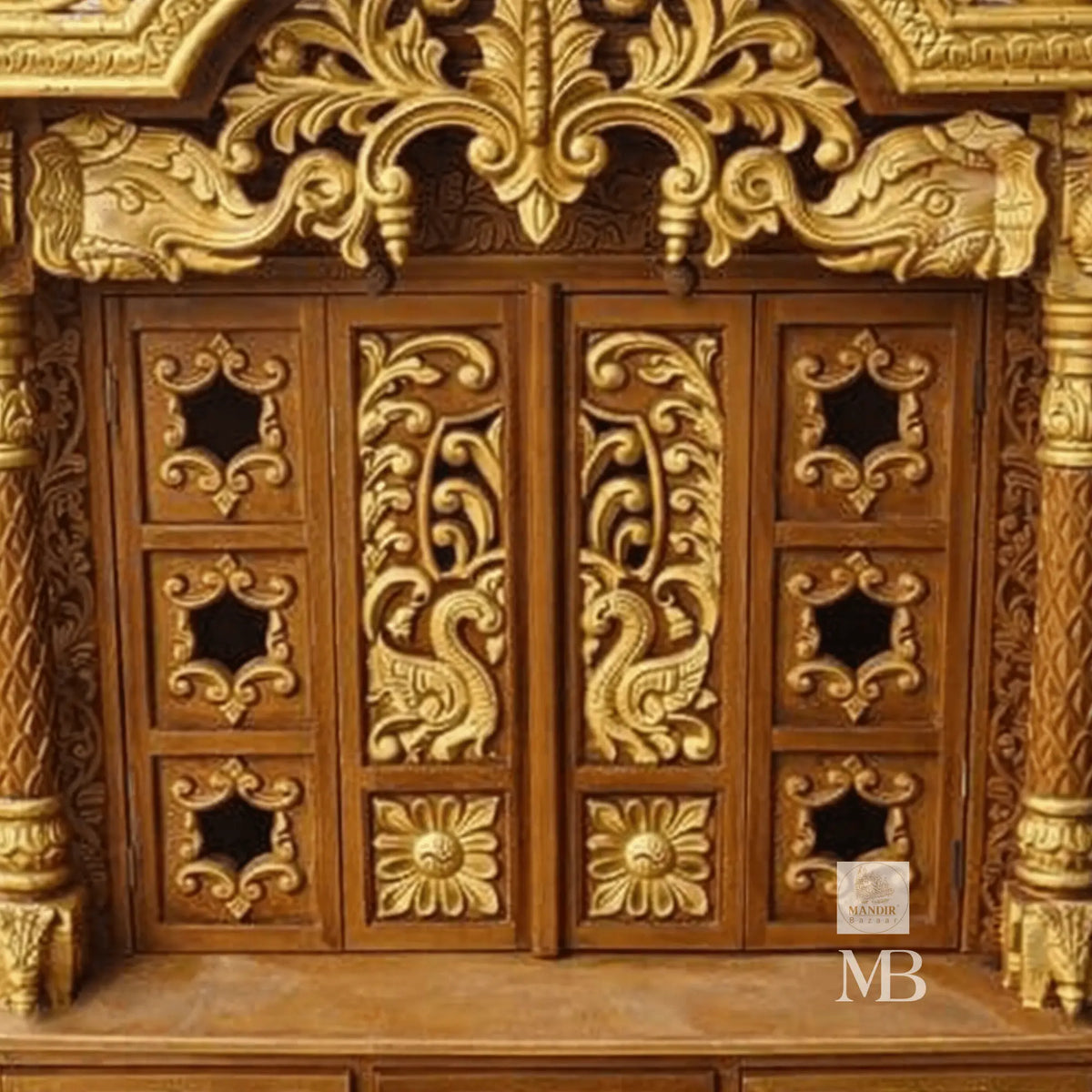 Close up view of arched peacock shikhara crown carving and floral storage drawer details on Sheesham mandir