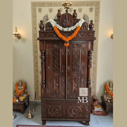 Front view of 6 feet tall dark walnut Sheesham wood home temple with closed carved doors and Ganesha crown