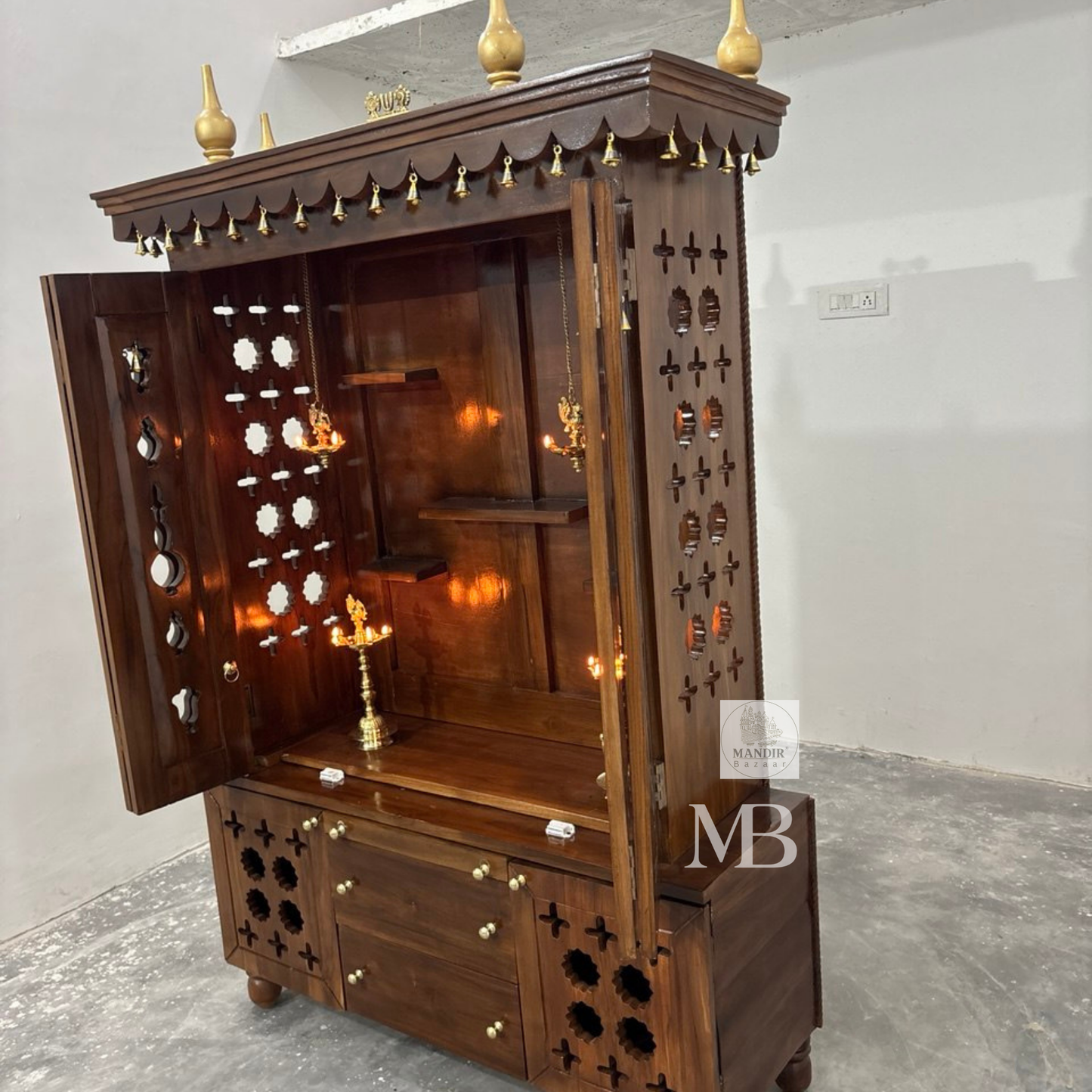Traditional teak wood pooja mandir cabinet design with shelves, storage drawers and decorative jaali panels