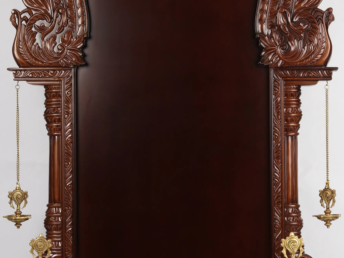 Large wooden Hindu temple frame with traditional brass lamps