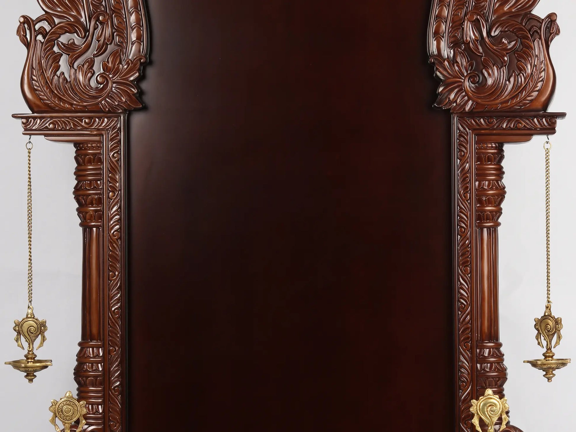 Large wooden Hindu temple frame with traditional brass lamps