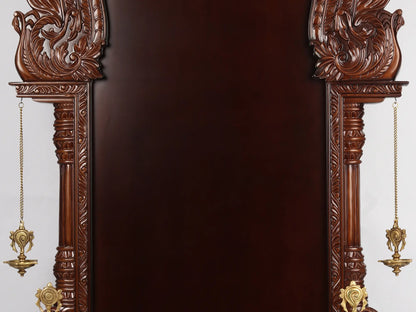 Large wooden Hindu temple frame with traditional brass lamps