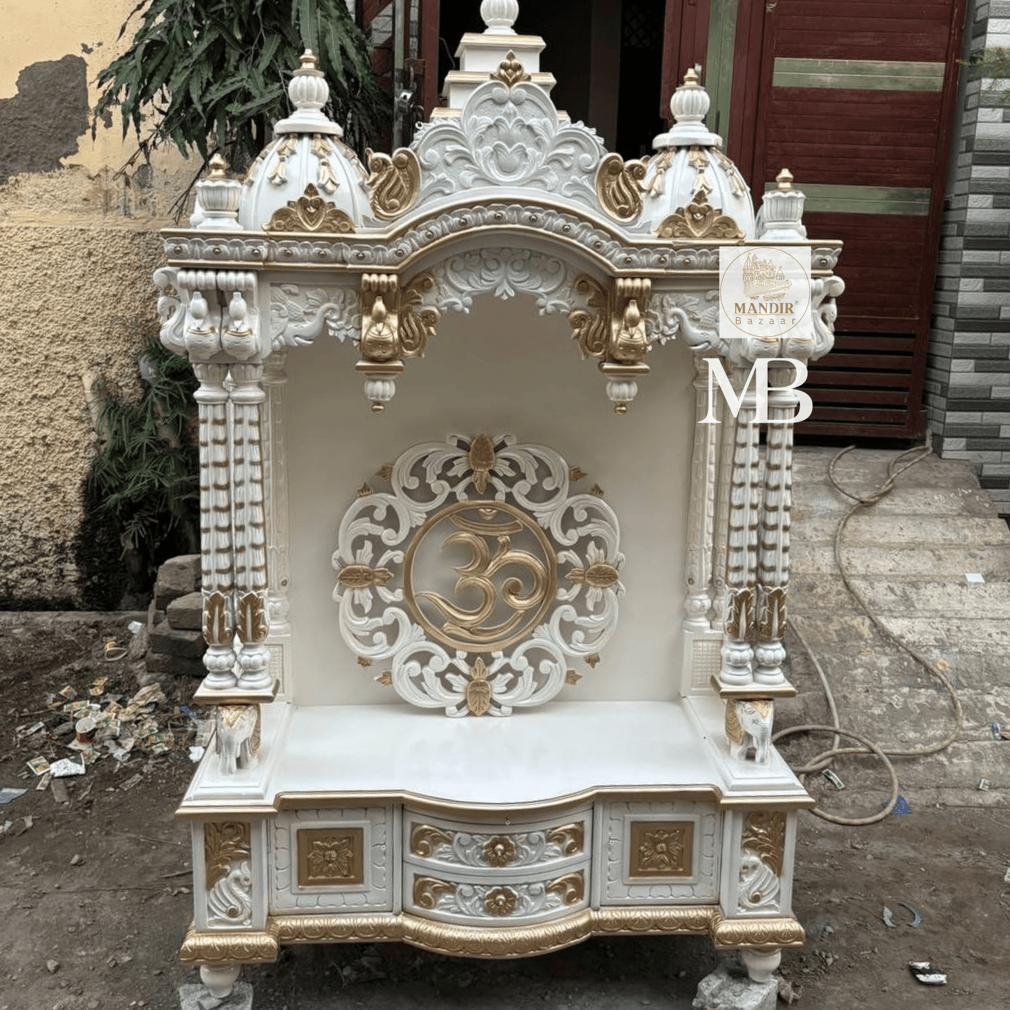 White and gold hand carved wooden mandir for home with Om design and storage cabinet