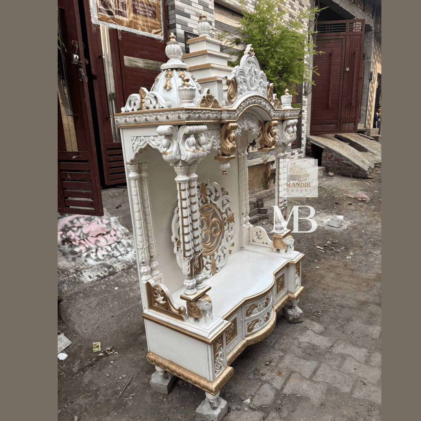 White and gold hand carved wooden mandir for home with Om design and storage cabinet