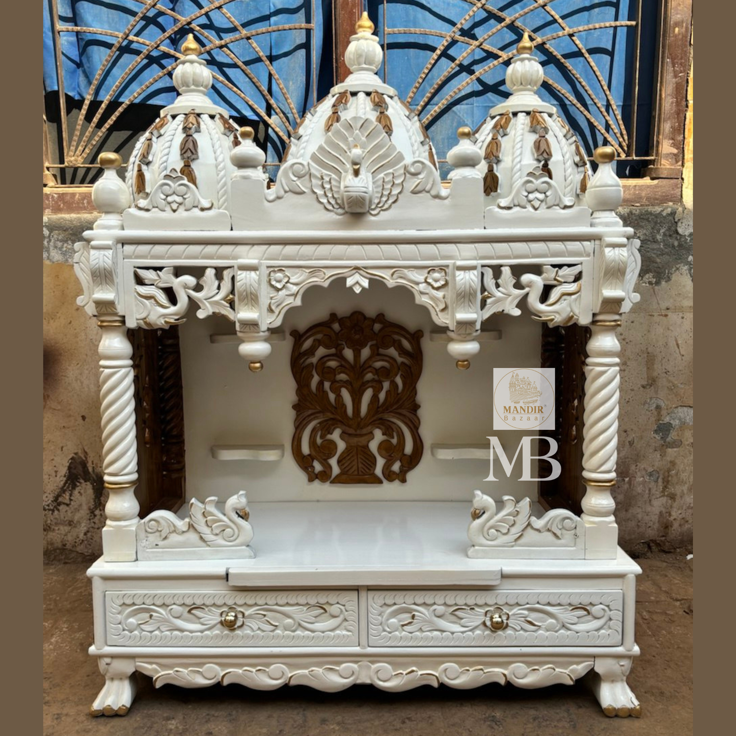 Handcrafted white wooden home temple with gold carved highlights and triple peacock domes