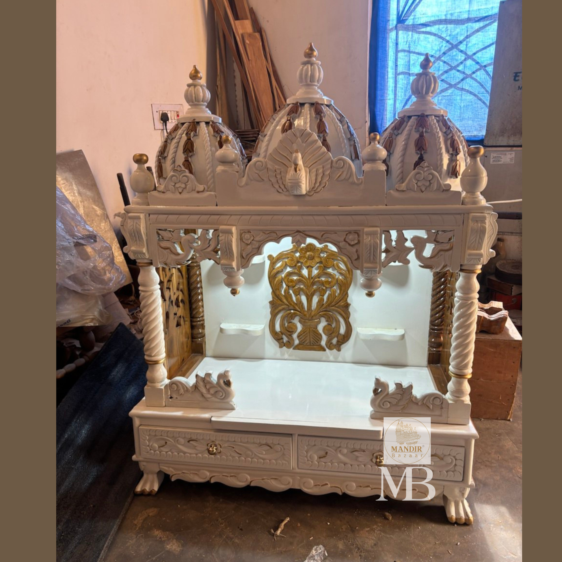 : Detailed carved swan motifs and storage drawers with floral patterns on white wooden temple