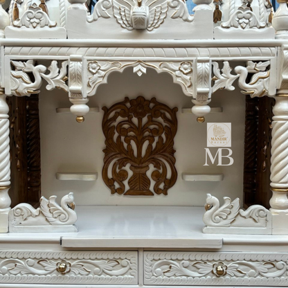 Handcrafted white wooden home temple with gold carved highlights and triple peacock domes