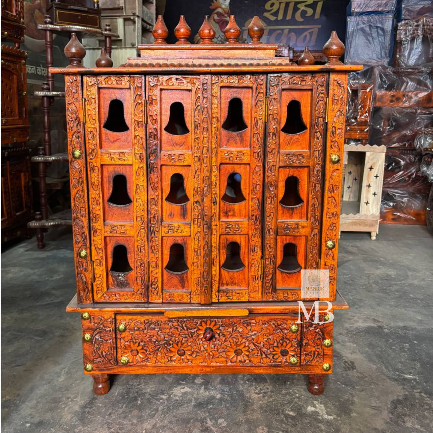 Wooden mandir with decorative brass bells and rich brown wood finish