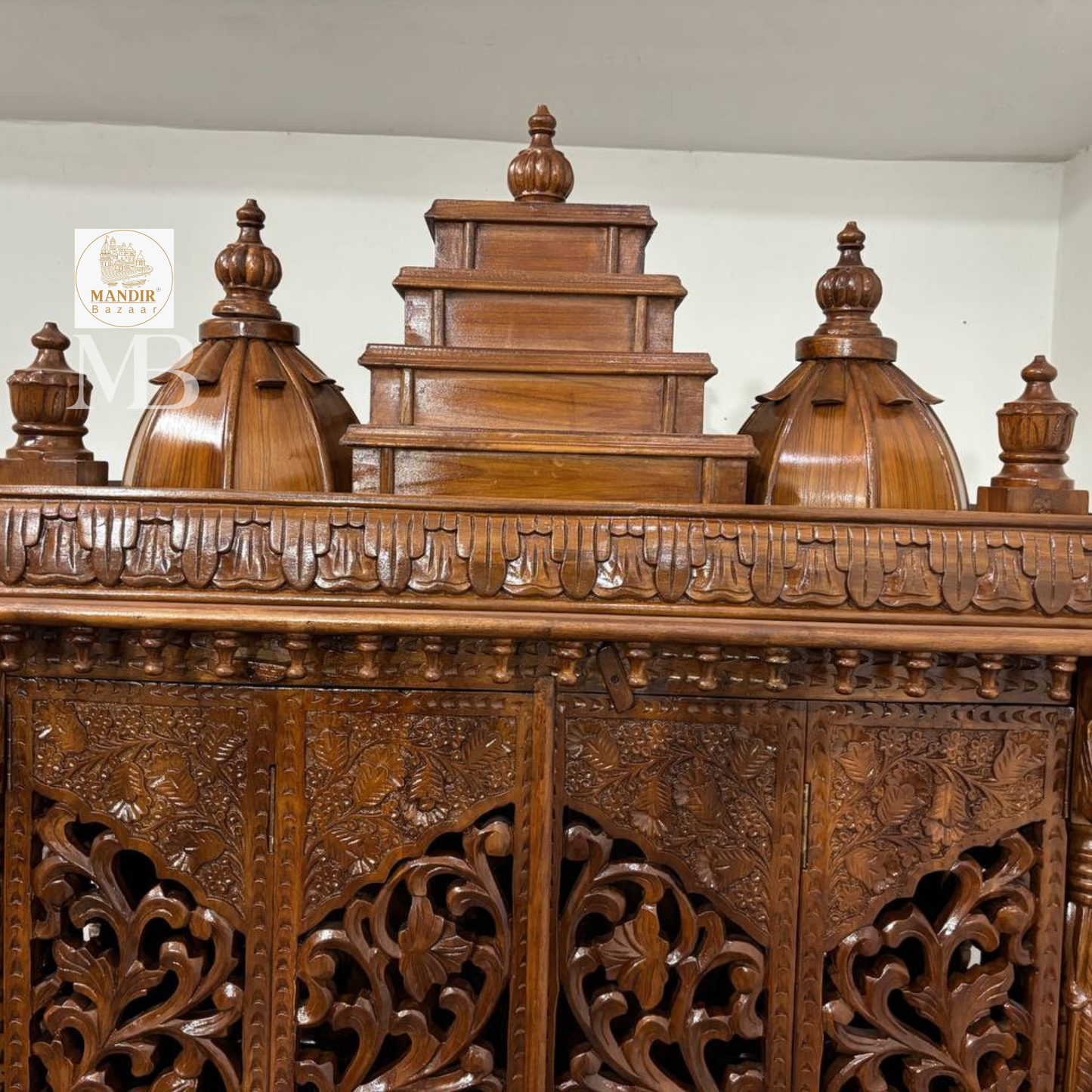 Ornate wooden pooja mandir with traditional temple-style crown
