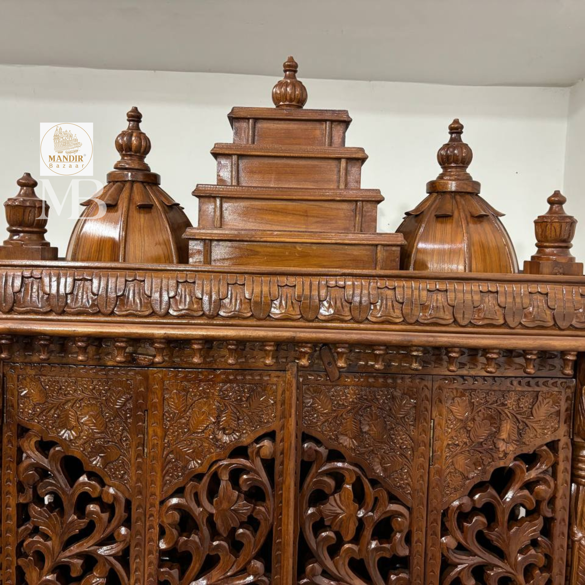 Ornate wooden pooja mandir with traditional temple-style crown