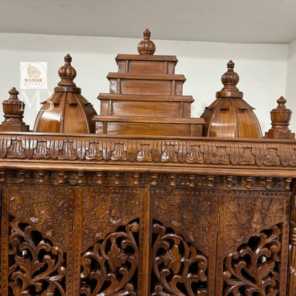 Ornate wooden pooja mandir with traditional temple-style crown