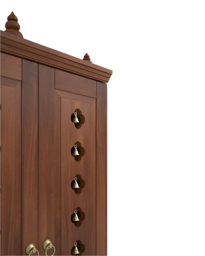 Traditional wooden mandir with decorative brass bells