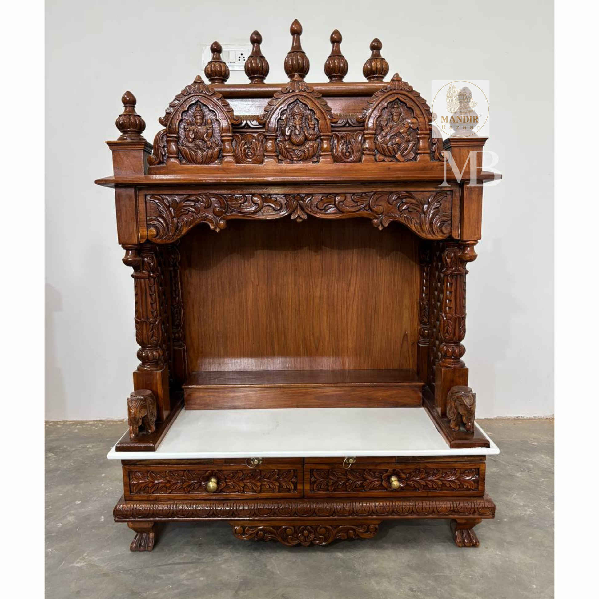 Handcrafted wooden pooja mandir for home with carved deities and marble platform
