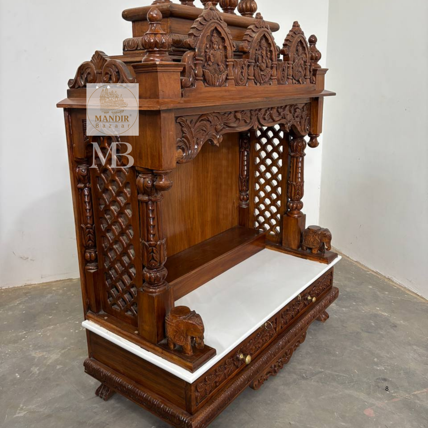 Decorative elephant carvings on handcrafted wooden pooja mandir